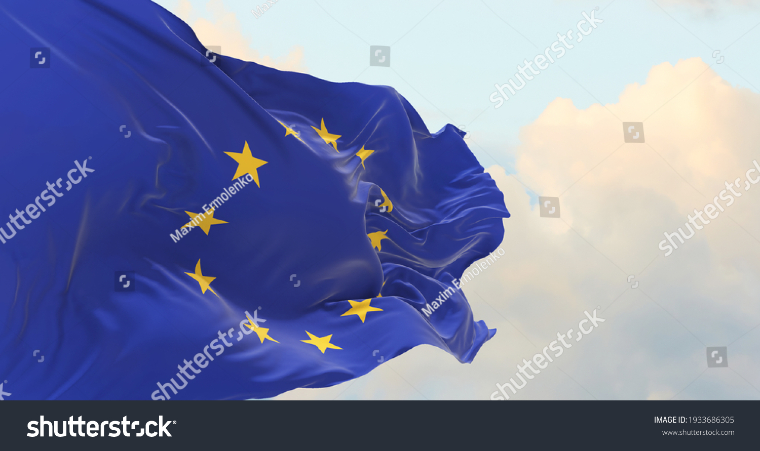 Flag of the European Union waving in the wind on flagpole against the sky with clouds on sunny day #1933686305