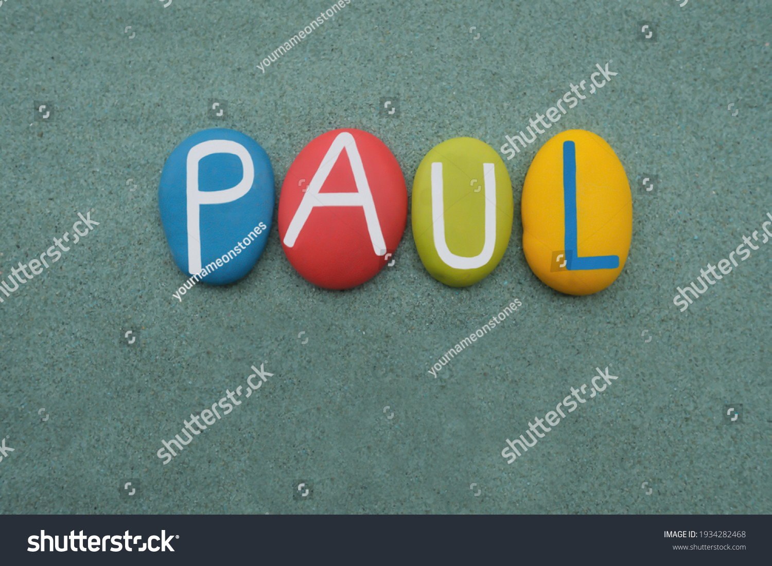 Paul, male given name composed with multi colored stone letters over green sand #1934282468