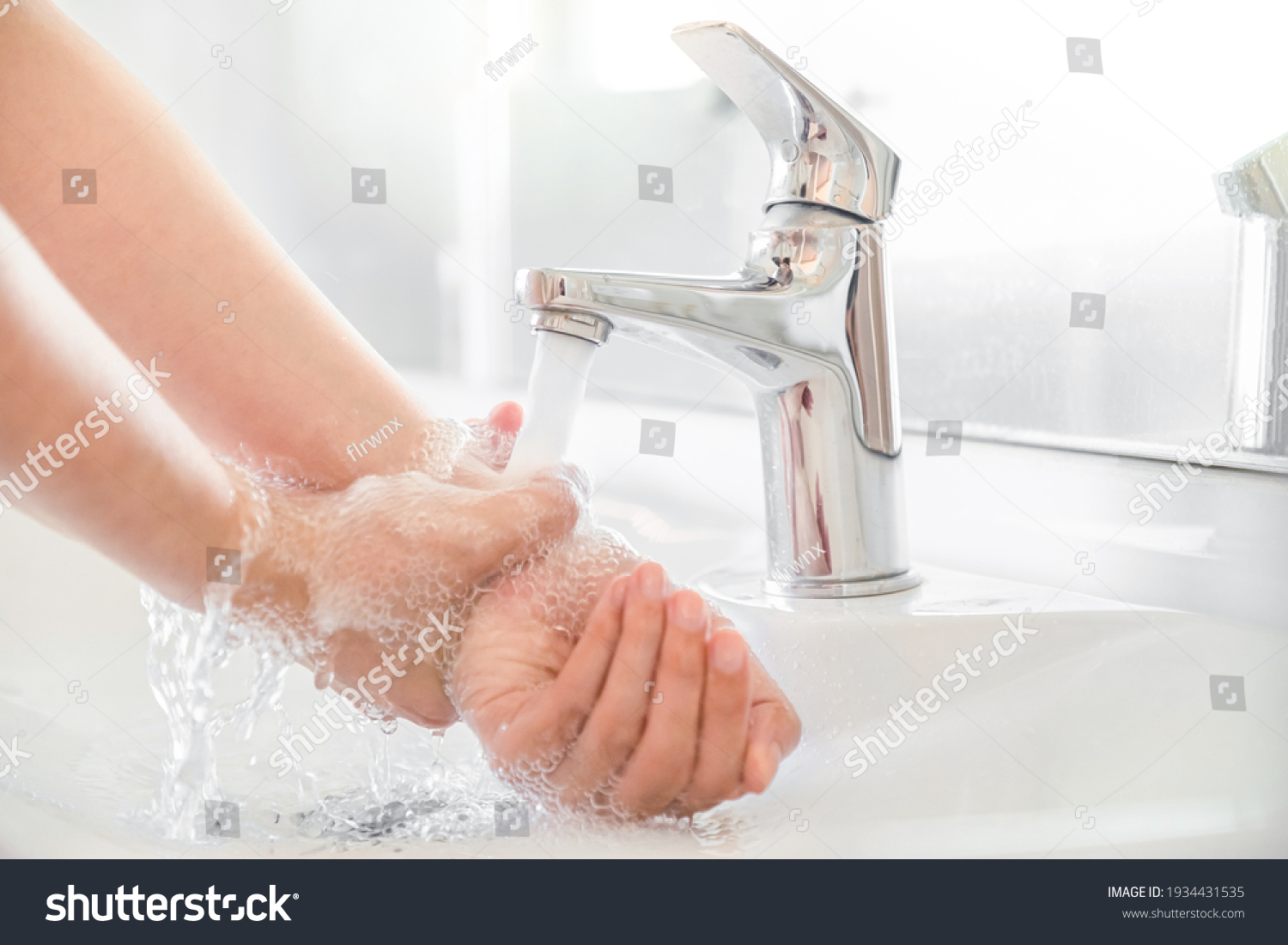 Woman use soap and washing hands rubbing with soap under the water tap. Hygiene new normal concept to stop spreading coronavirus or influenza virus in hospital or public wash room. #1934431535