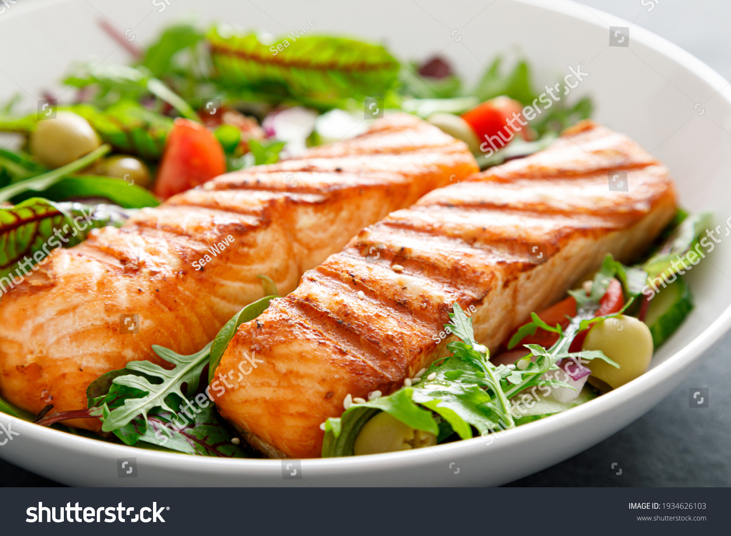 Grilled salmon fillet and fresh vegetable salad. Mediterranean diet.  #1934626103