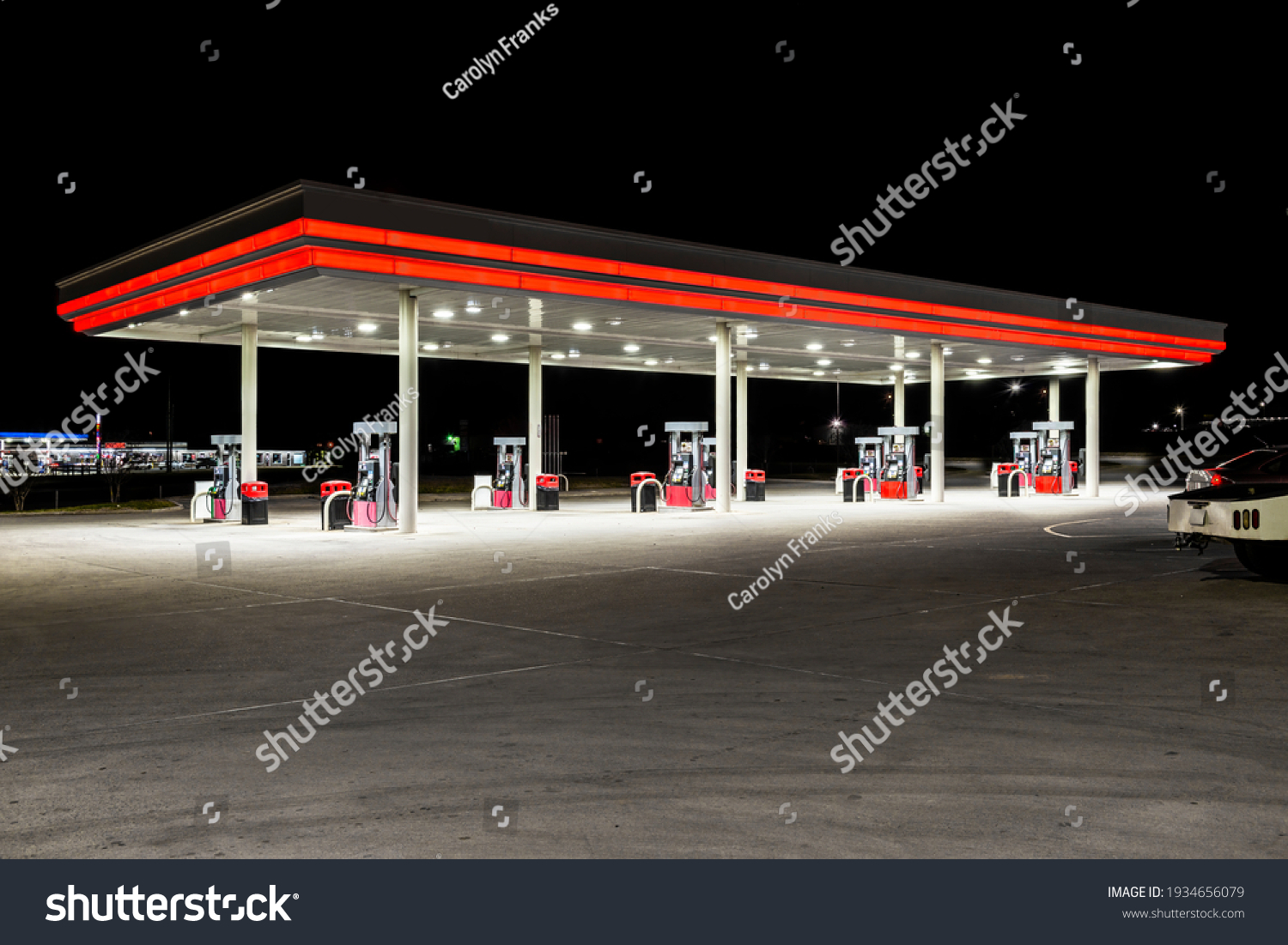 Horizontal shot of a generic unbranded gas station at night with copy space at the top and bottom. #1934656079