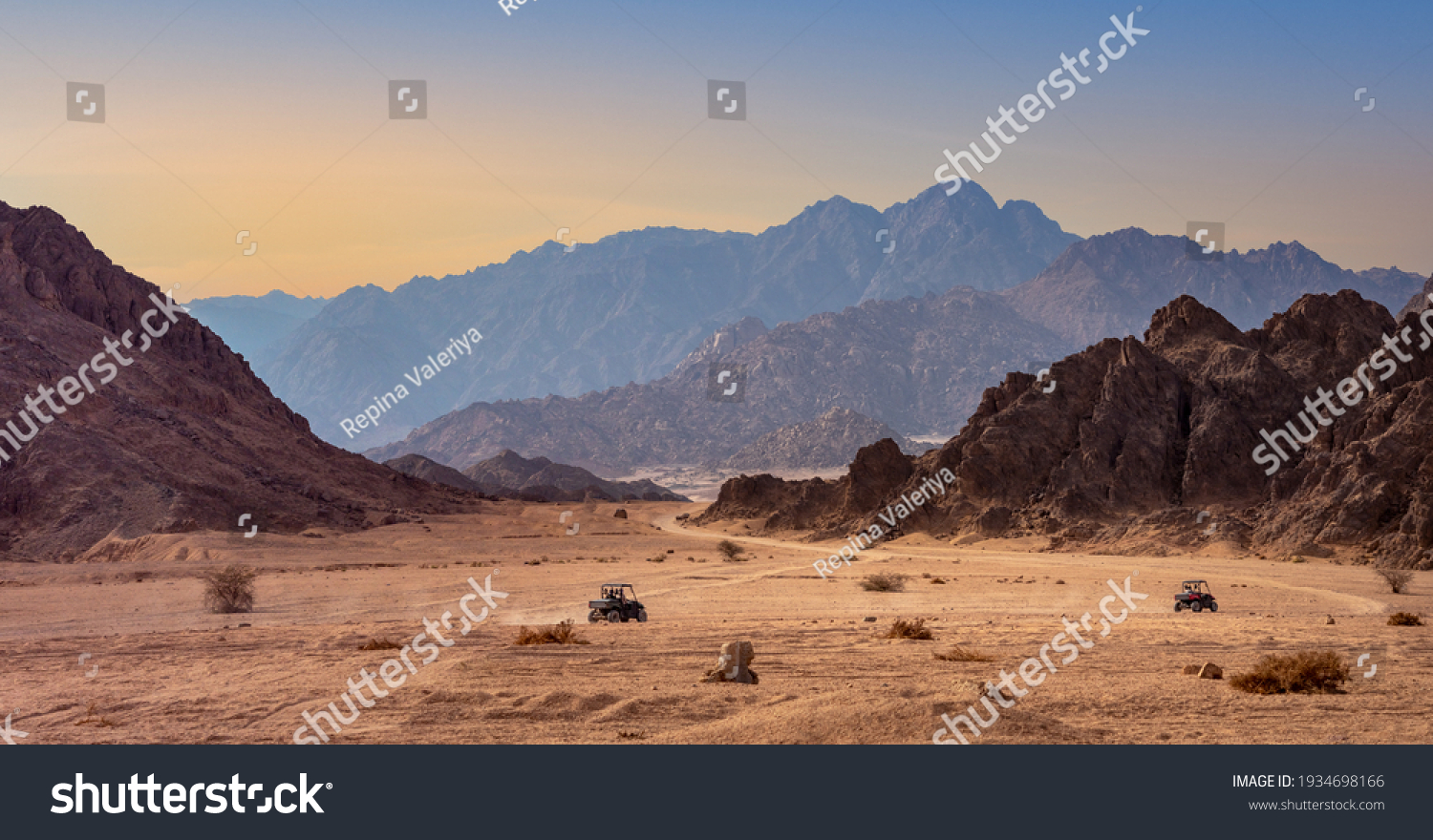 Buggy trip in a stone desert at sunset. Mountain landscape with off-road vehicles driving on a dust dirt road. Active leisure for tourists in Sharm el-Sheikh resorts, Egypt. #1934698166