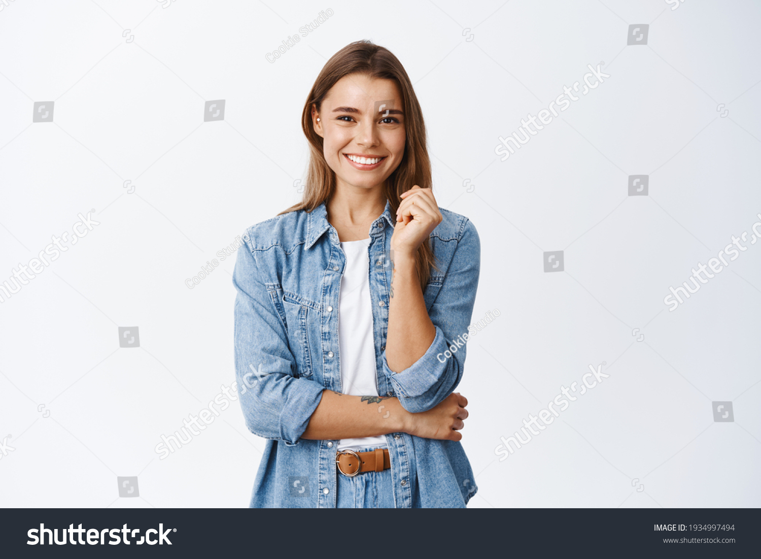 Happy successful woman standing in casual outfit, smiling pleased at camera and looking confident, standing against white background #1934997494