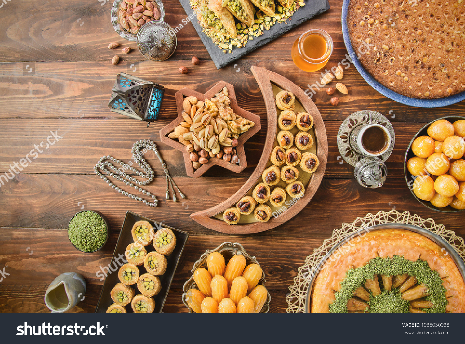Arabic Cuisine: Middle Eastern desserts. Delicious collection of Ramadan traditional desserts. Served with tasty nuts, Arabic coffee, honey syrup and sugar syrup .Top view with close up. #1935030038