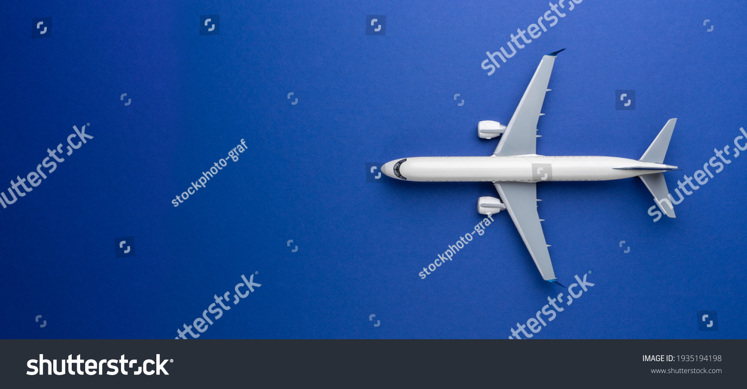 Top view of white commercial passenger airline airplane jet on blue background with copy space. Transportation tourism travel aviation and business concept. #1935194198