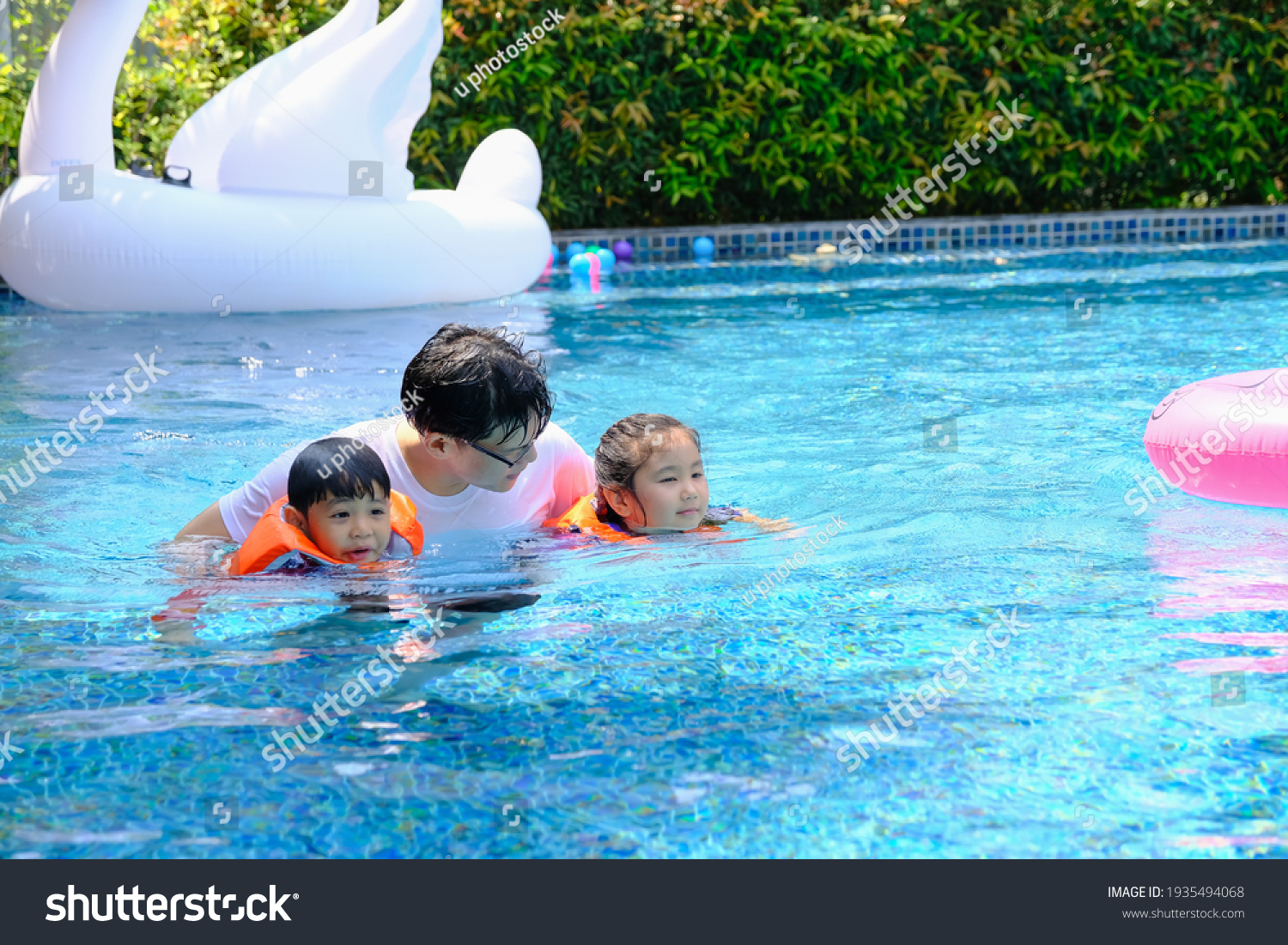 happy asia single dad with son and daughter playing in swimming pool #1935494068