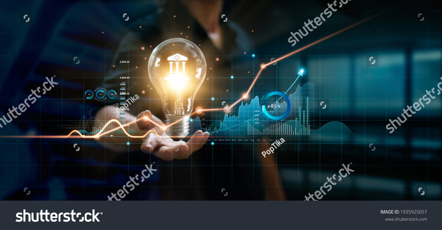 Businessman holding creative light bulb with growth graph and banking icons. Financial innovation technology develop new products and services that enhance successful and profit in global business. #1935925057