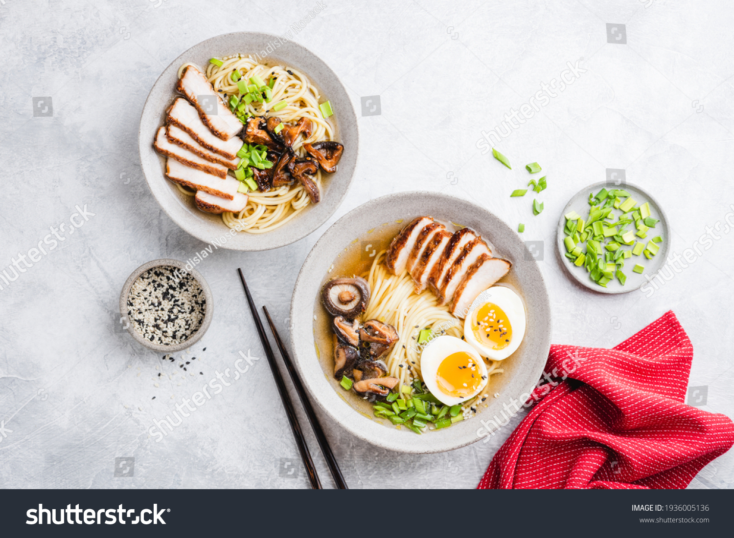 Chicken ramen, asian noodle soup. Two bowls of delicious homemade chicken ramen noodle soup with shiitake mushrooms on a grey concrete background, table top view #1936005136