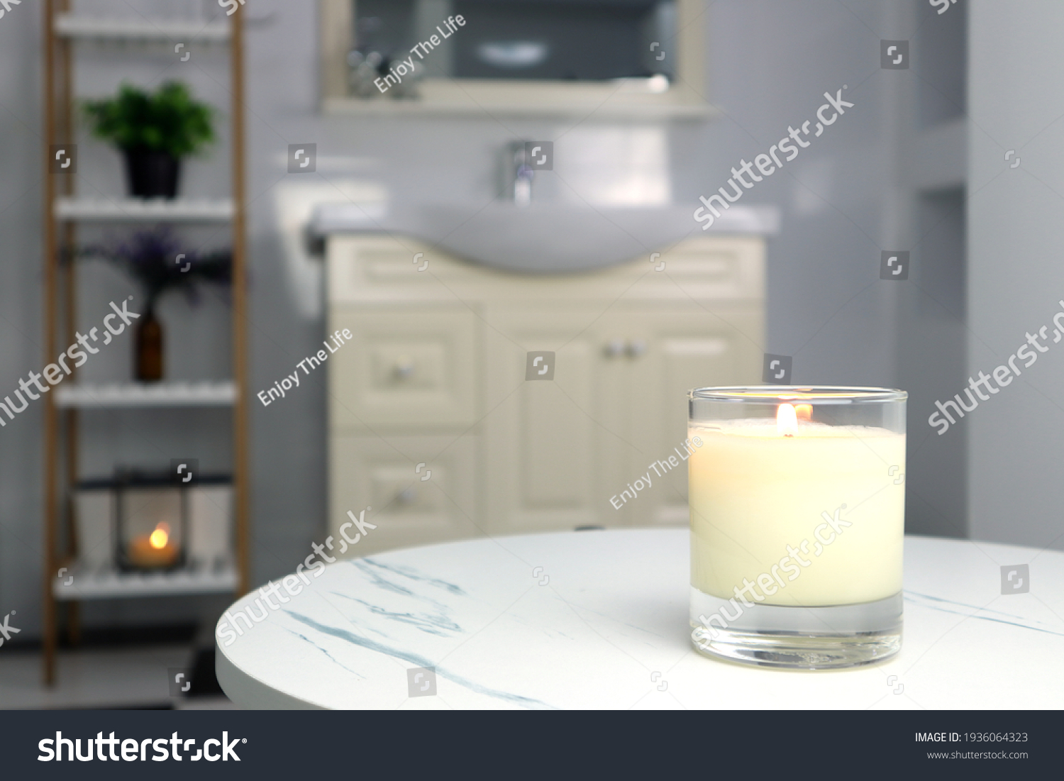 aromatic scented candle glass is put on the white marble table in a luxury white bathroom toilet to creat relax and cozy and clean ambient
 #1936064323