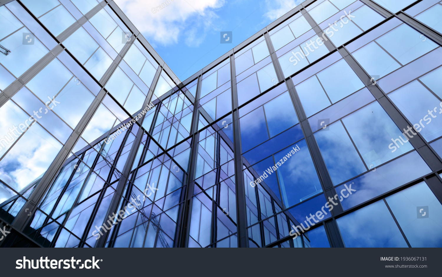 Modern office building with glass facade on a clear sky background. Transparent glass wall of office building. #1936067131