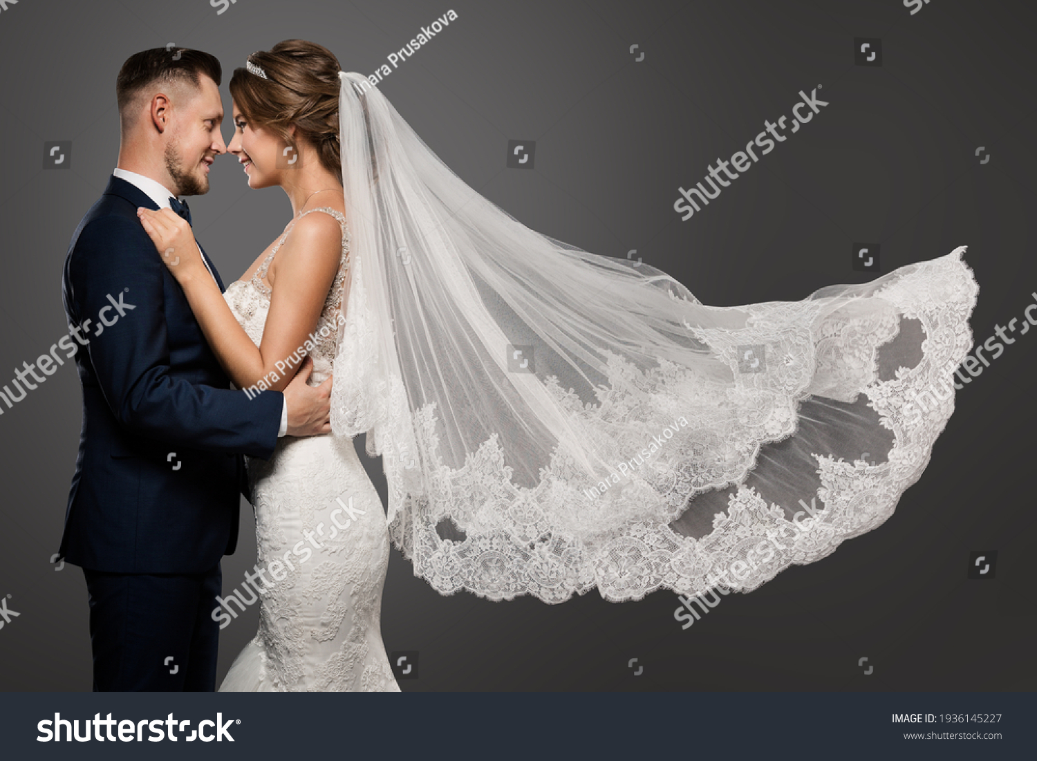 Wedding Couple Dancing. Romantic Bride and Groom Portrait. Bridal long Veil flying over Gray Studio Background #1936145227