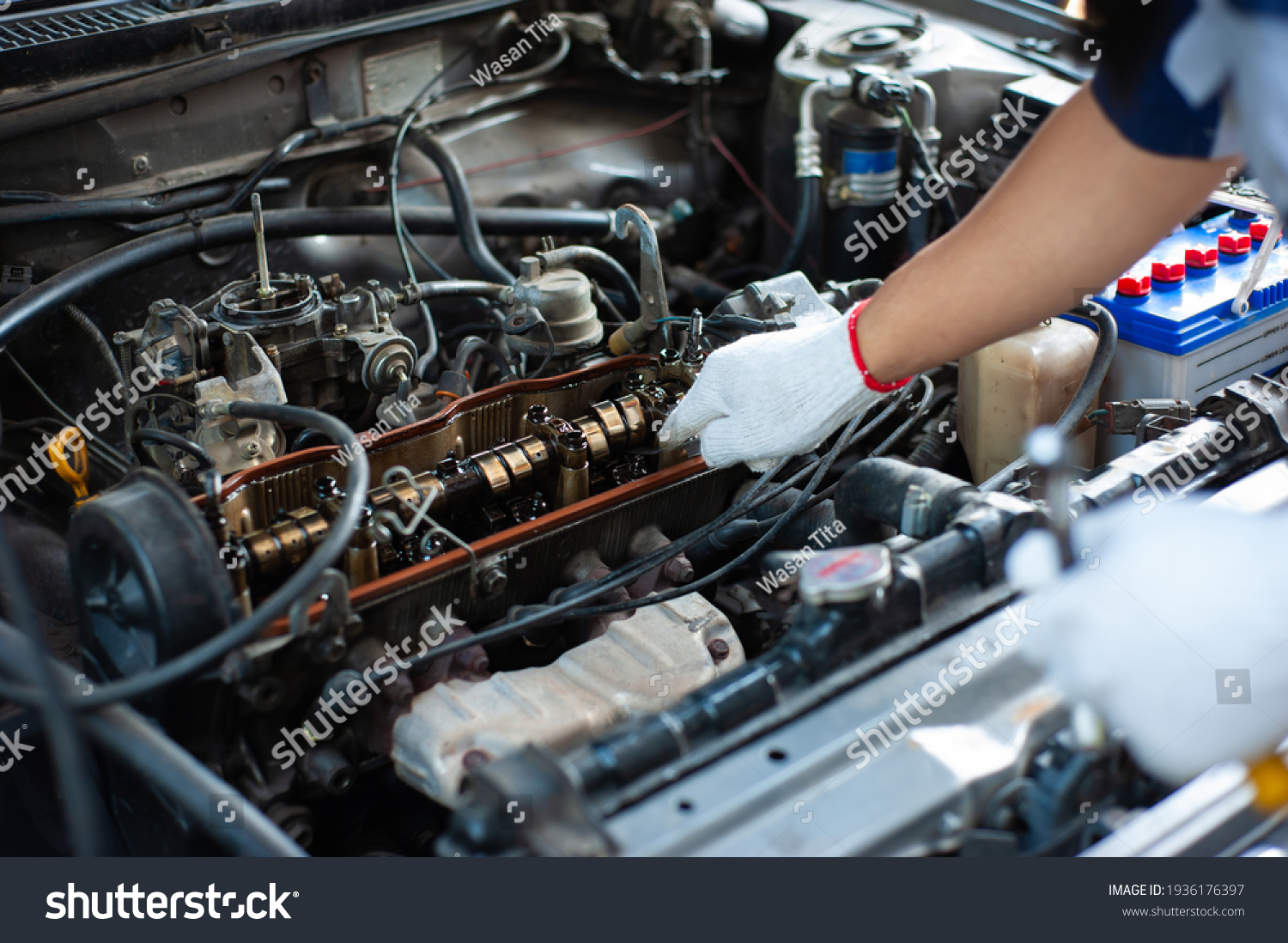 The mechanic is tuning the car's engine. #1936176397
