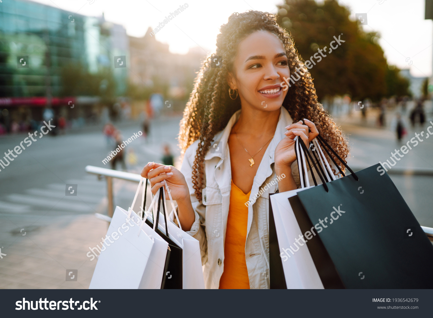 Fashion woman with shopping bags walking on street. Spring Style. Consumerism, sale, purchases, shopping, lifestyle concept. #1936542679