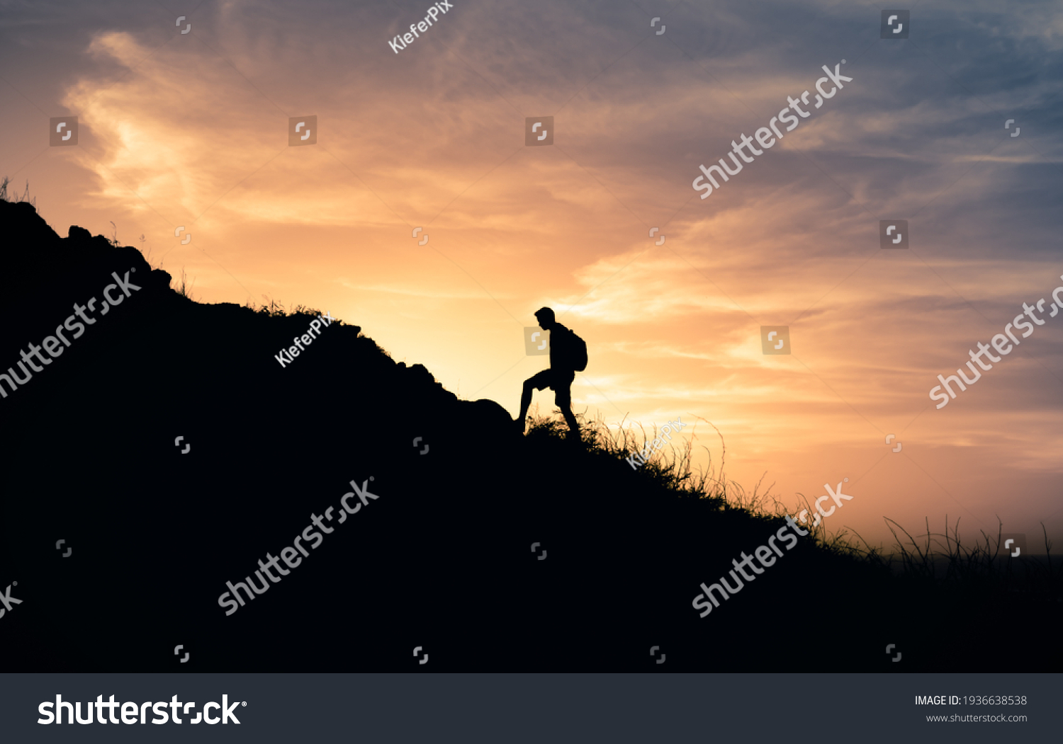 Male hiker climbing up the edge of mountain. Adventure and freedom concept.  #1936638538