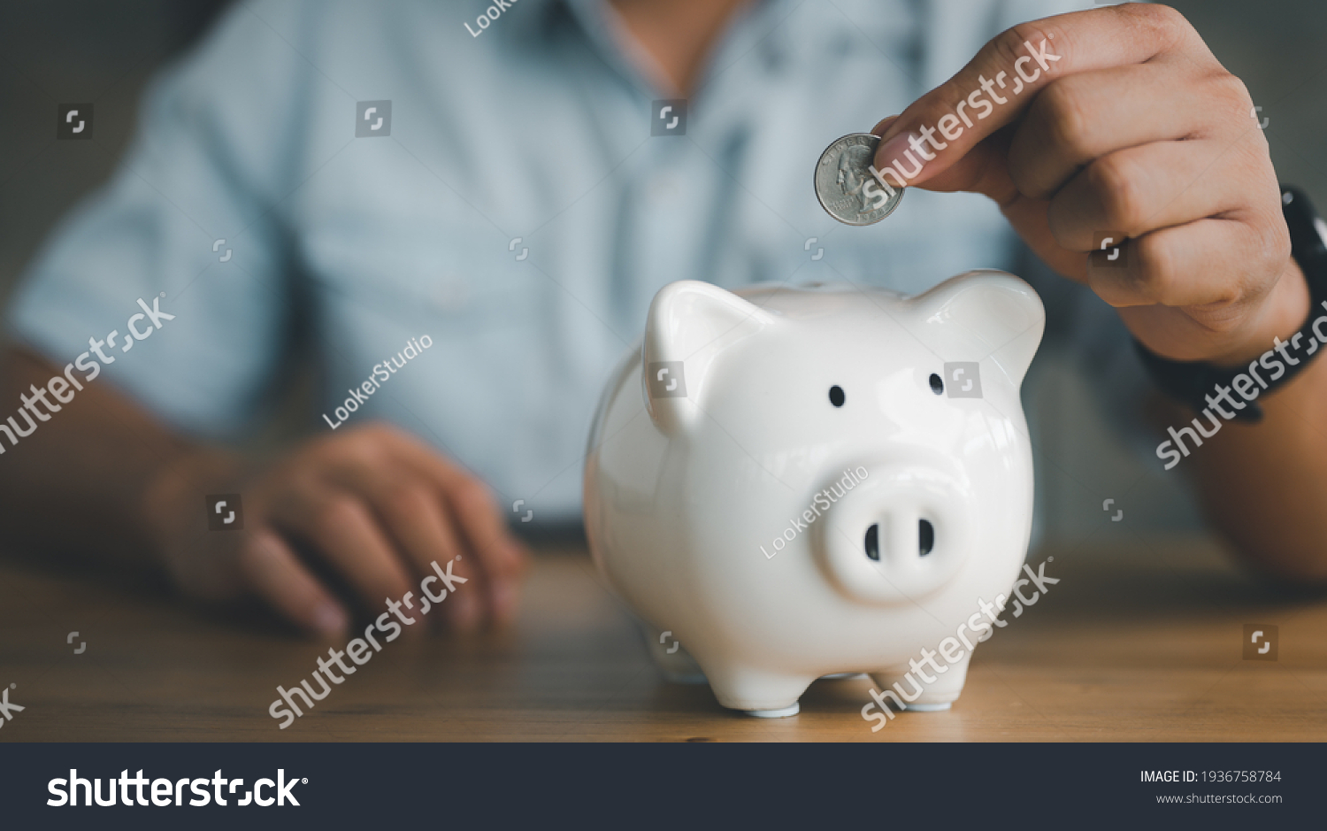businessman hand putting coin in piggy bank. Saving money concept, business finance and investment. #1936758784