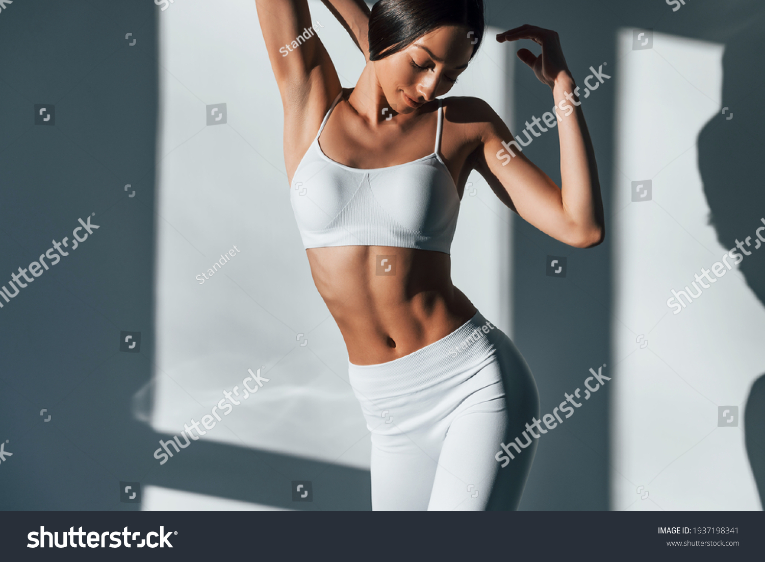 Shows her body. Young caucasian woman is indoors at daytime. #1937198341