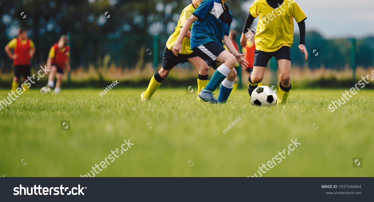Young boys playing soccer game. Kids having fun in sport. Happy kids compete in football game. Running soccer players. Competition between players running and kicking football ball. Football school #1937240464