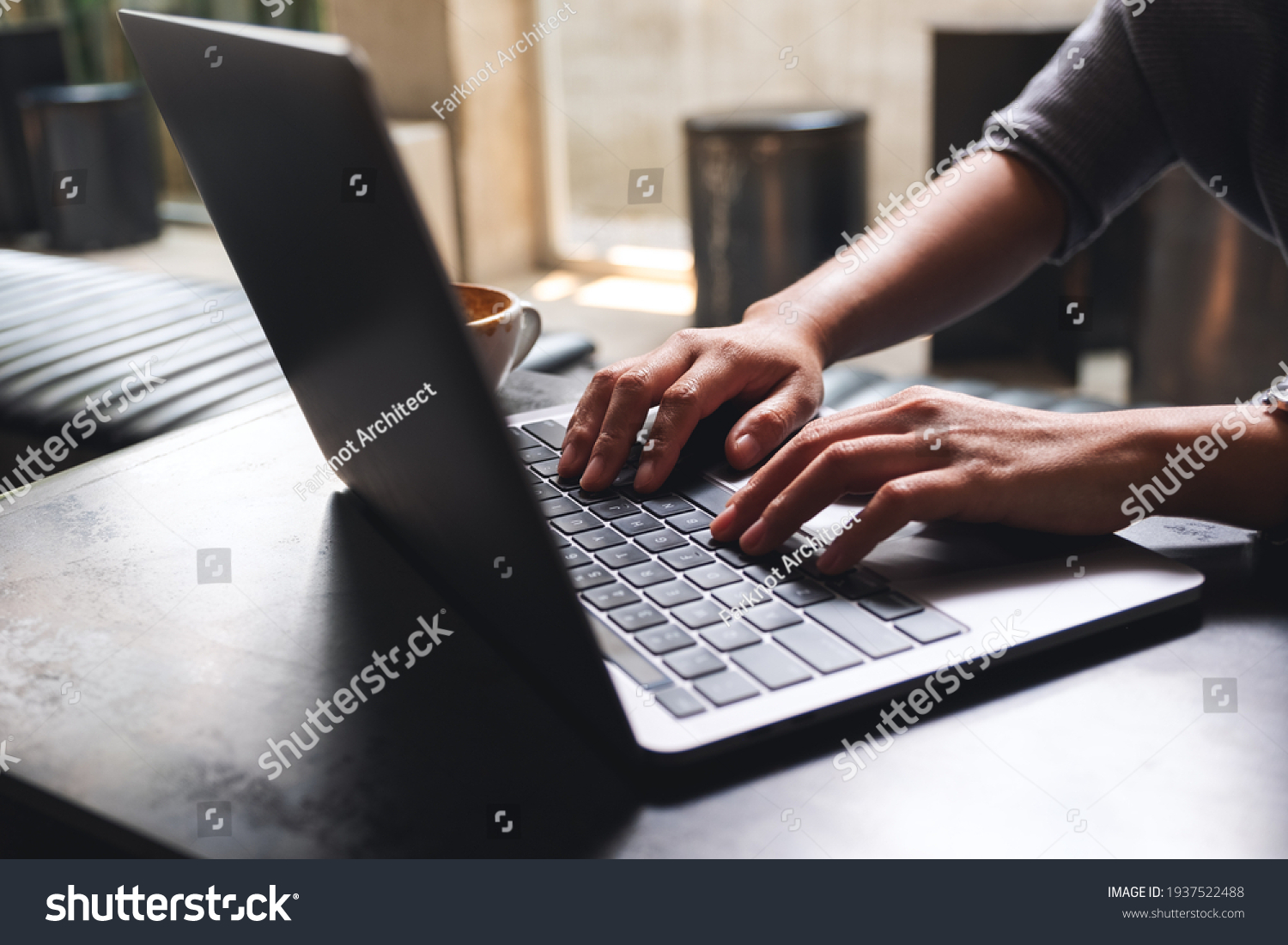 Closeup image of a woman working and typing on laptop computer keyboard on wooden table #1937522488