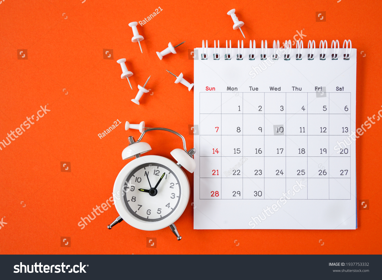white calendar page , alarm clock and thumbtacks on grunge  orange paper background  #1937753332