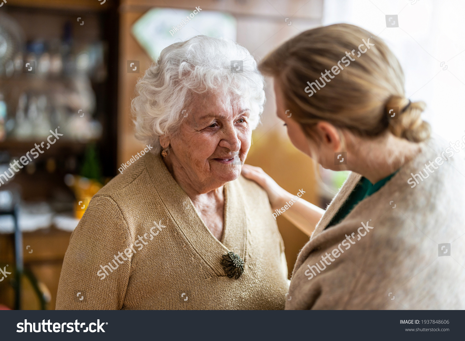 Health visitor talking to a senior woman during home visit
 #1937848606