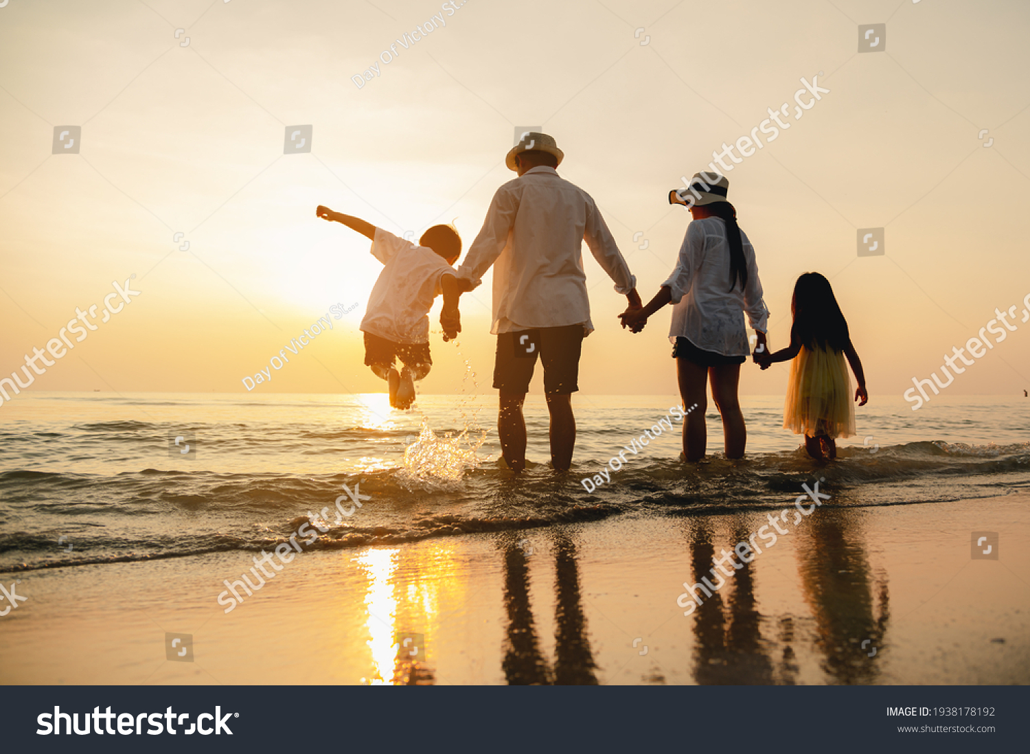 Happy asian family jumping together on the beach in holiday. Silhouette of the family holding hands enjoying the sunset on the  beach.Happy family travel and vacations concept.  #1938178192