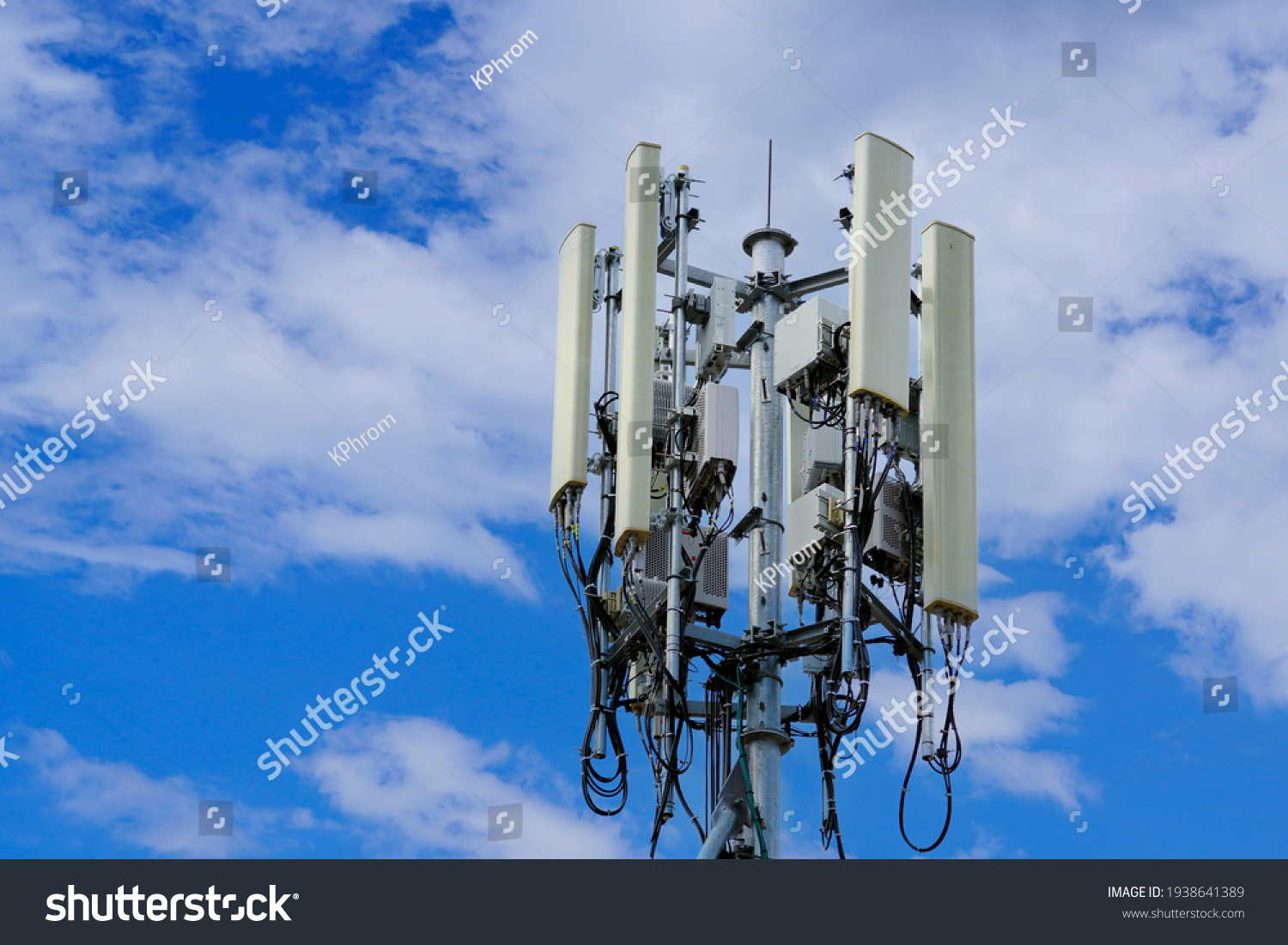 Telecommunication tower of 4G and 5G cellular. Macro Base Station. 5G radio network telecommunication equipment with radio modules and smart antennas mounted on a metal on cloulds sky background. #1938641389