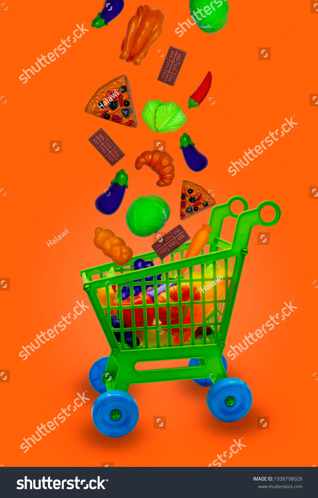 Toy Shopping cart with different toy food falling in den Shopping cart,Background color orange. #1938798028