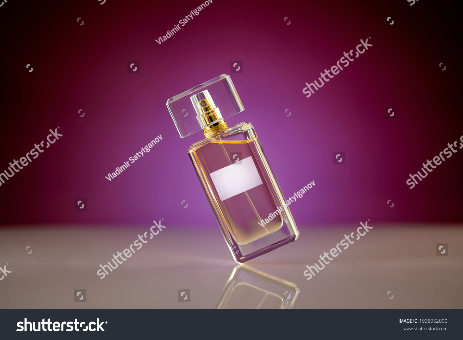 Tilted unbranded perfume bottle on glassy surface, magenta gradient background. Beauty and fashion concept #1938952090