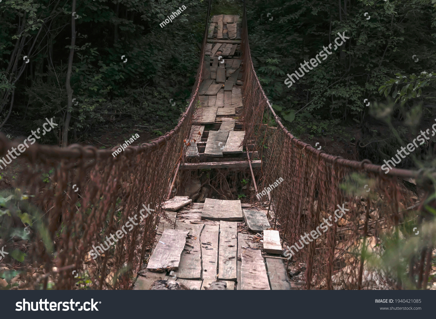 Destroyed suspension bridge over a mountain river (concept: dangerous path) #1940421085