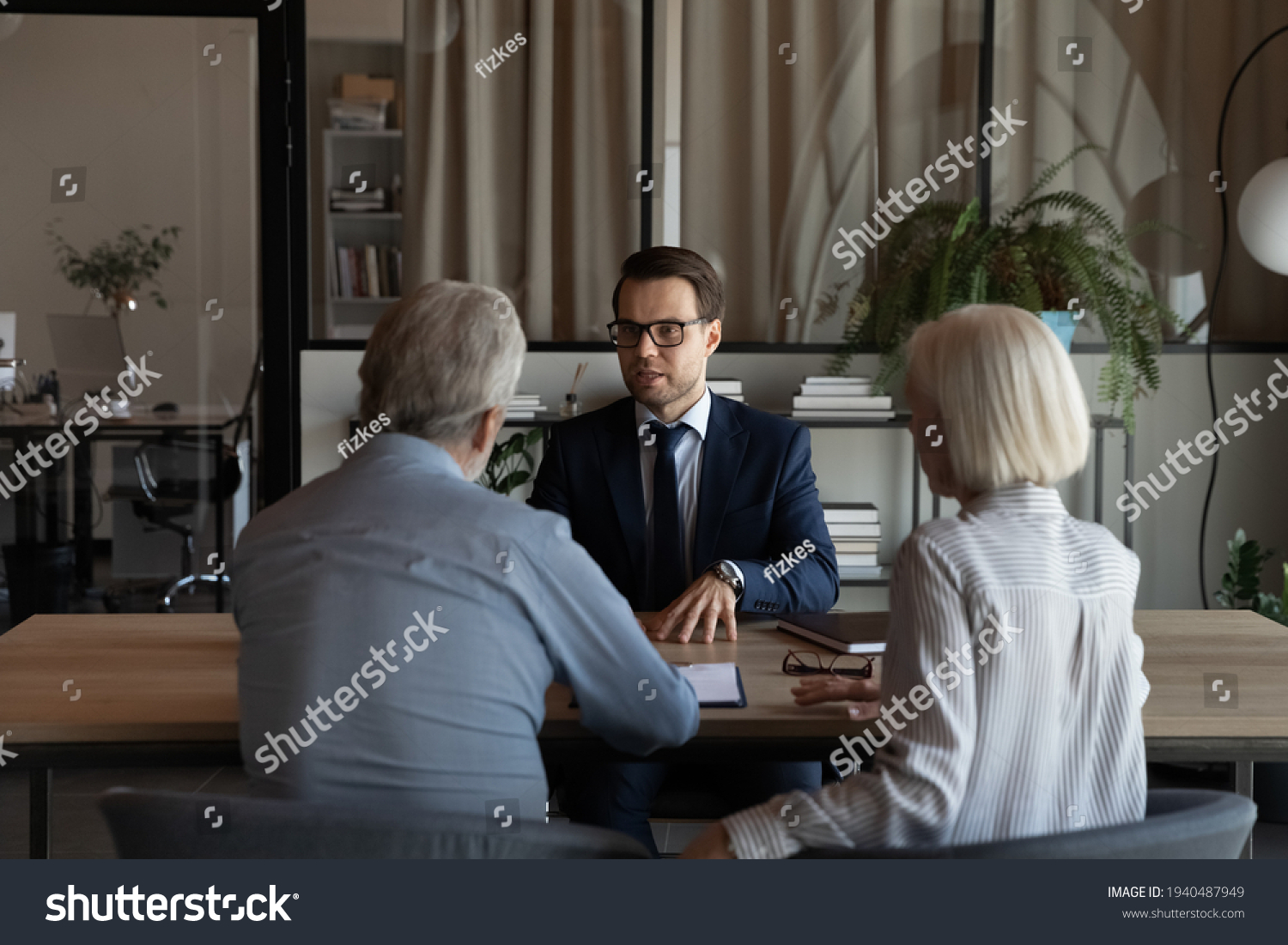 Male Caucasian specialist have meeting with mature couple clients, discuss health insurance for older people. Middle-aged spouses customers consult with relator or broker. Realty, rent concept. #1940487949