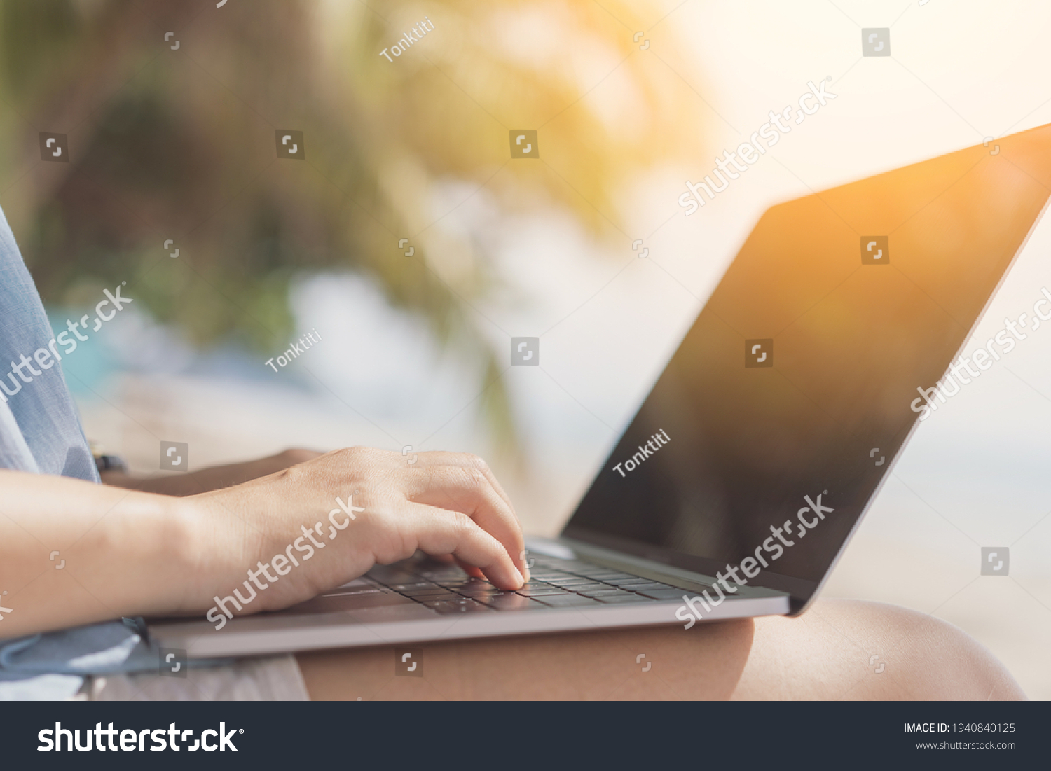 Woman using laptop on tropical beach background. Freelance working and travel vacation concept. #1940840125