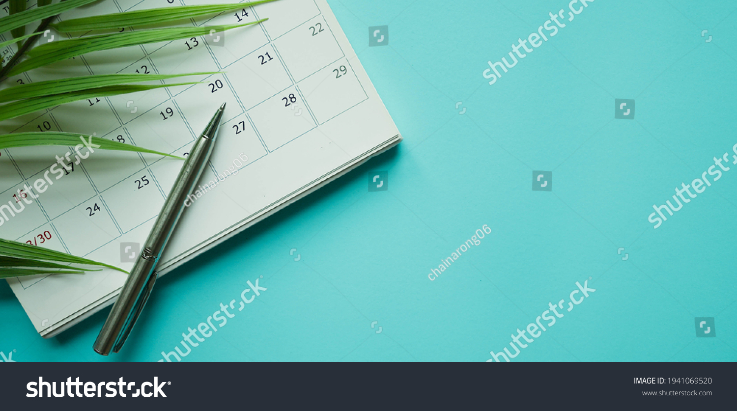 close up top view on white calendar 2021 with pencil and tropical leaves on blue color table background for planning work and life balance in holiday summer concept #1941069520