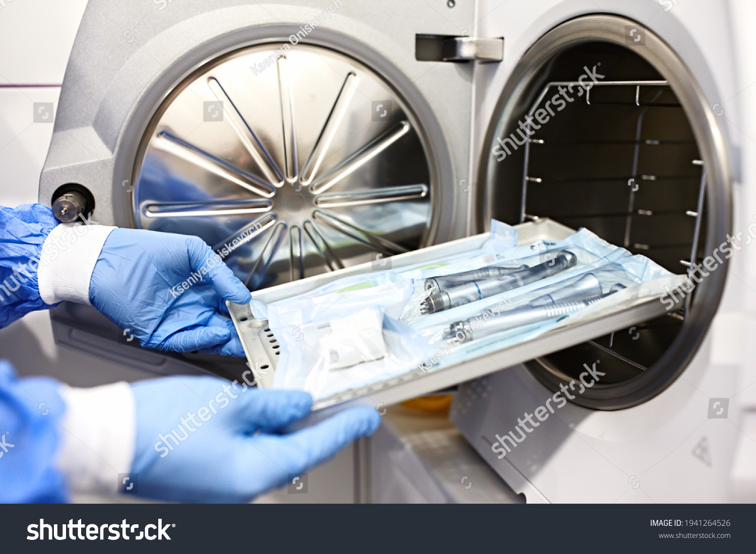 Nurse putting instruments in special craft paper bags into autoclave for processing.Laboratory equipment. Tools sterilization, bacterial purification and disinfection in dental clinic. Selective focus #1941264526
