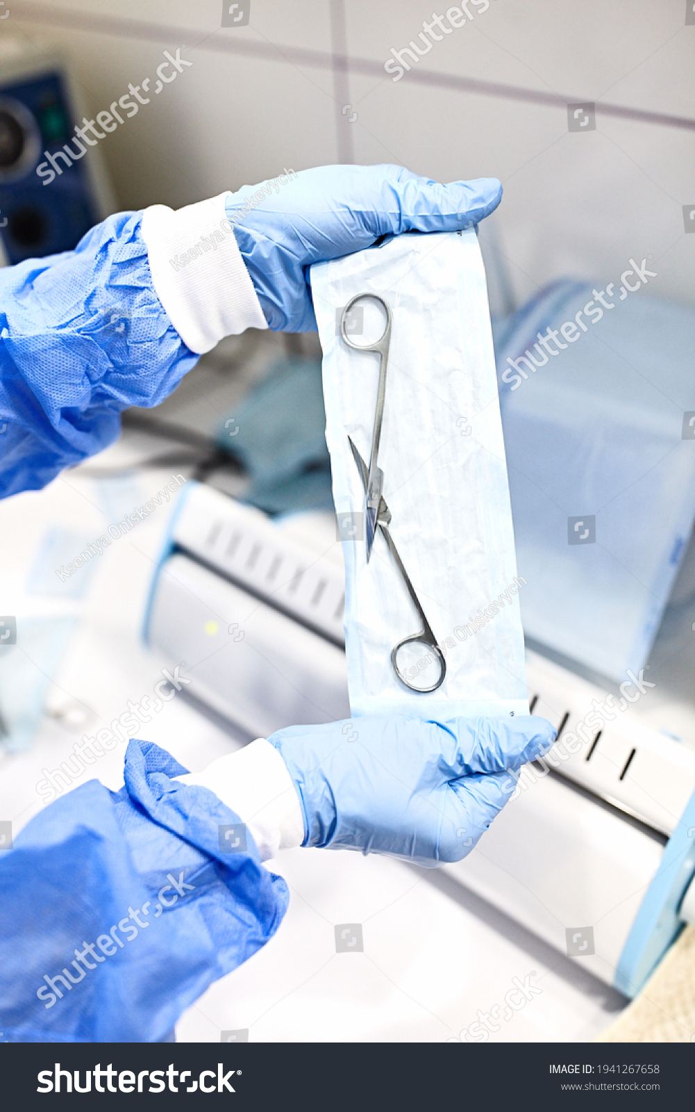 Sterilizing medical instruments in autoclave. Close up dentist assistant's hands holding packaged with vacuum packing machine medical instruments ready for sterilizing in autoclave. Medical scissors #1941267658