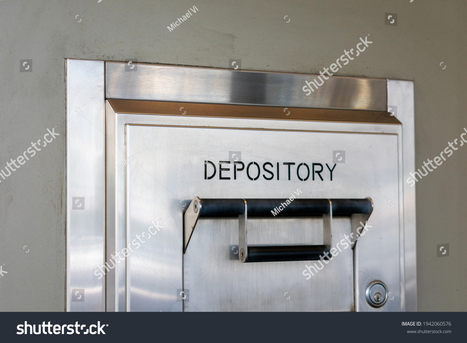 Depository sign on an exterior secured bank drop box attached to the wall of a bank building #1942060576