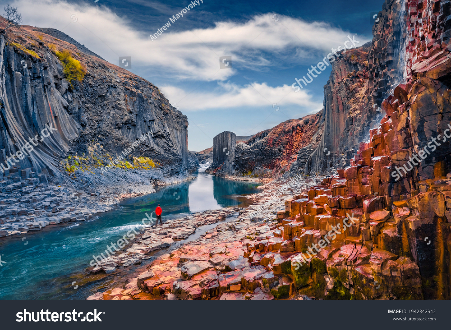 Tourist walking on the bottom of canyon with basalt columns. Unbelievable summer scene of Studlagil Canyon. Picturesque morning view of Iceland, Europe. Beauty of nature concept background. #1942342942