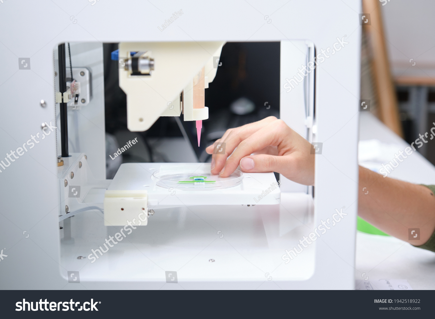 Researcher getting 3D bioprinter ready to 3D print cells onto an electrode. Biomaterials, tissue engineering concepts. #1942518922