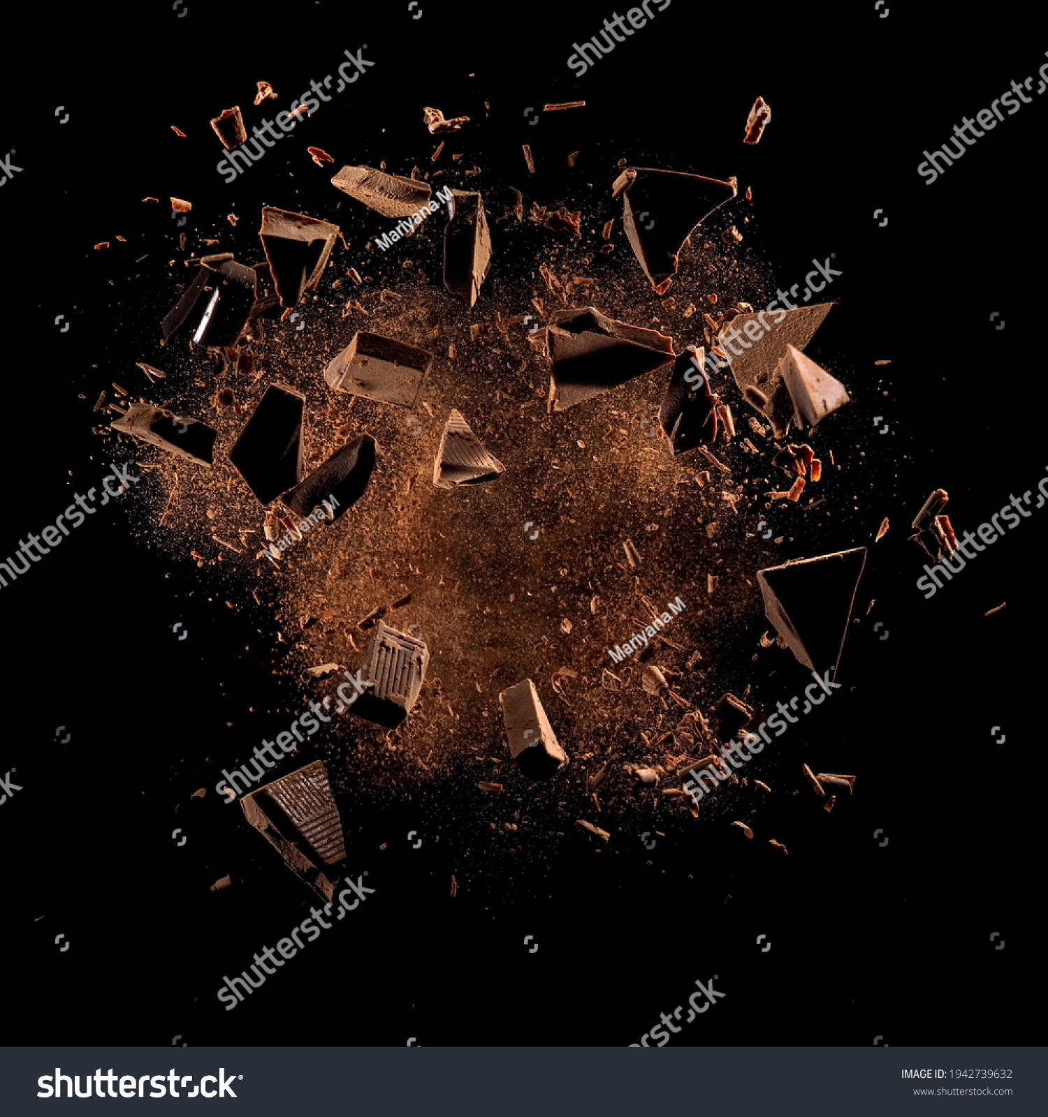 Cocoa powder with chocolate pieces and curls explosion on black backgrounds #1942739632
