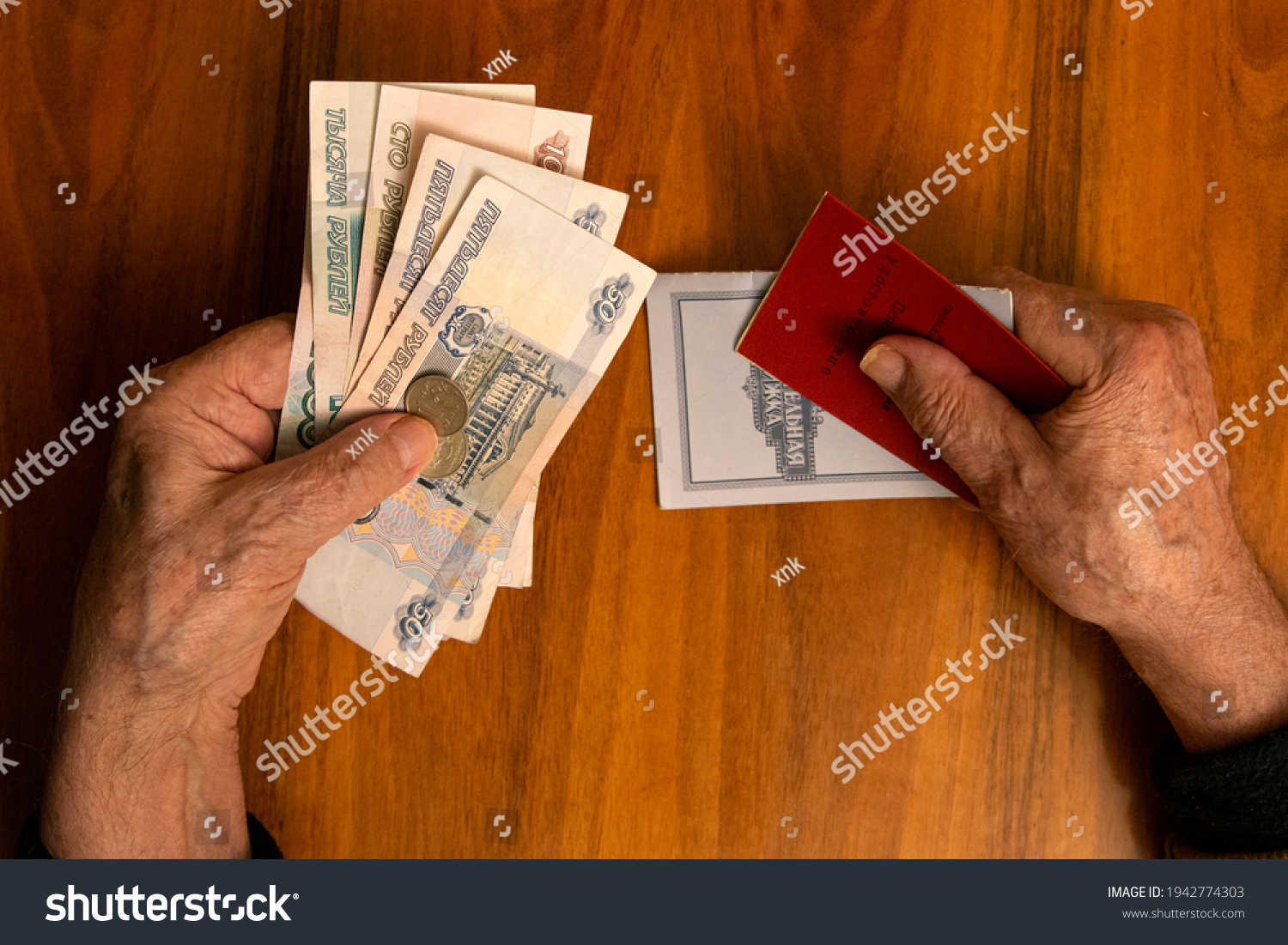 Elderly man holding russian ruble banknotes in one hand and pension certificate with passbook
in another. The concept of pension, payment and money savings. #1942774303