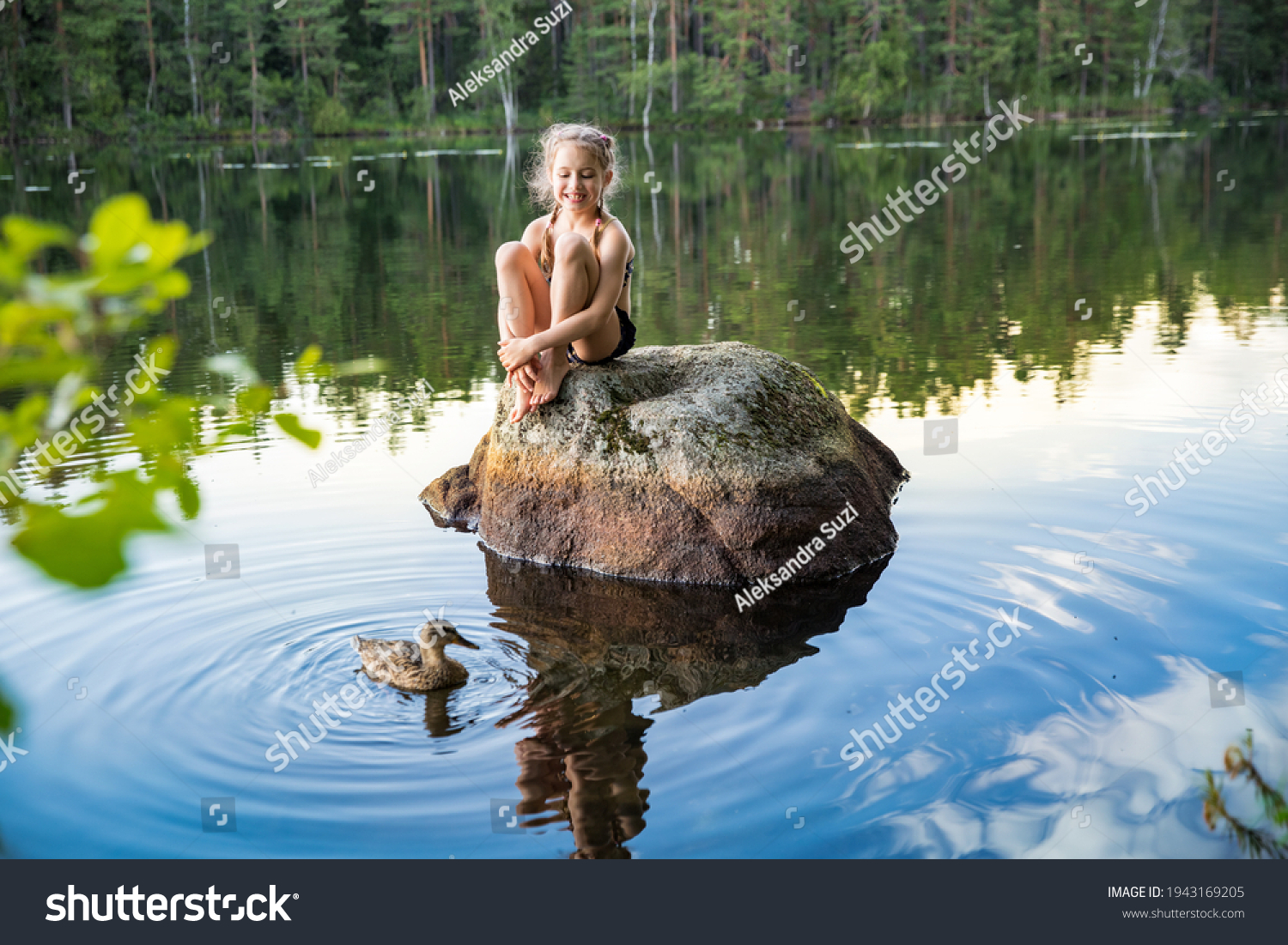 Cute little girl sitting on a rock in lake. Enjoying summer vacation. Child and Nature. Happy isolation concept. Exploring Finland. Scandinavian landscape.  #1943169205