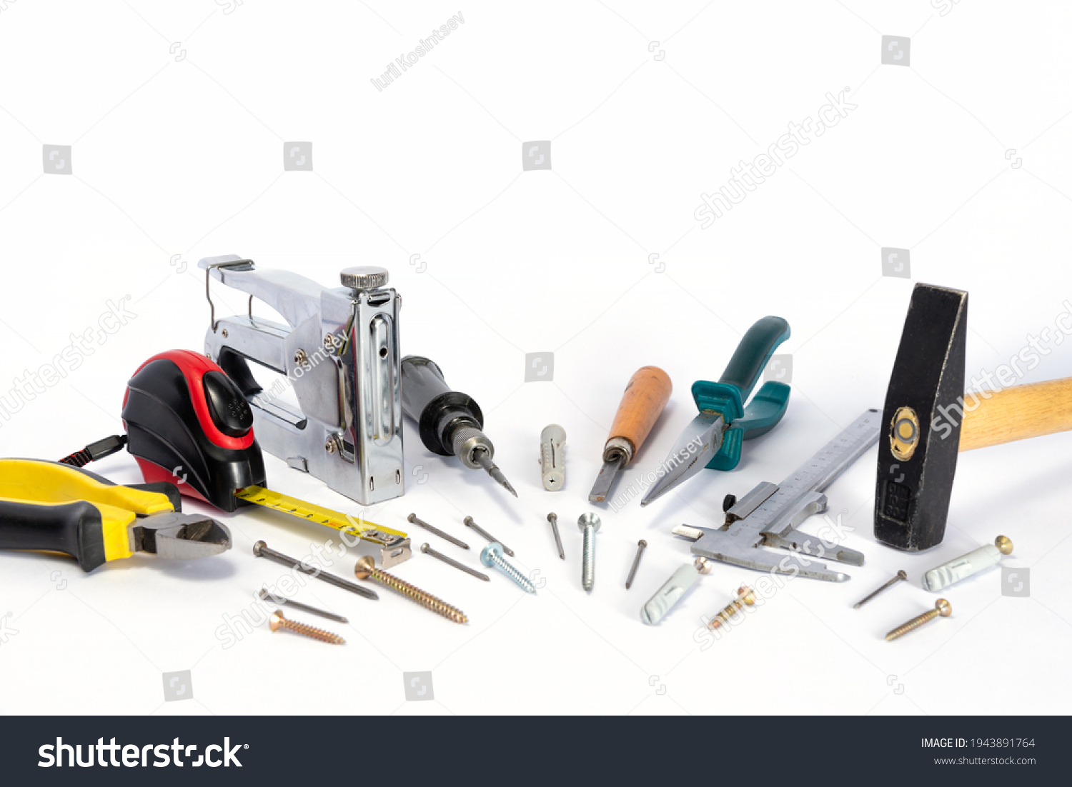 Tools and parts are on a white background. Metal object. A group of repair tools. Various parts and spare parts on the table. Tools for men. A set of working tools. #1943891764