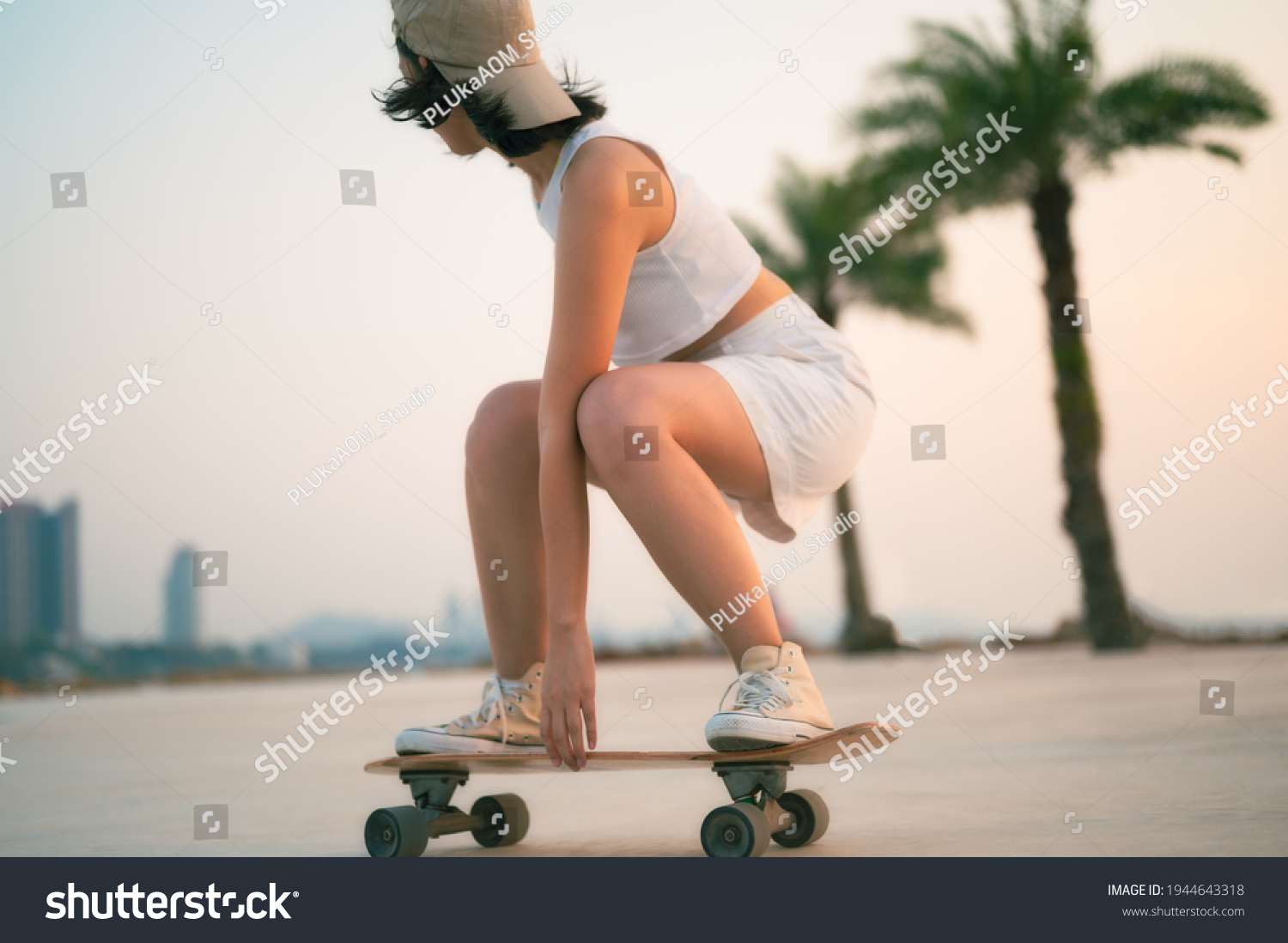 Asian Beautiful women surf skate or skateboard outdoors on beautiful summer day. Happy young women play surf skate at park near the beach on morning time. Sport activity lifestyle concept. #1944643318