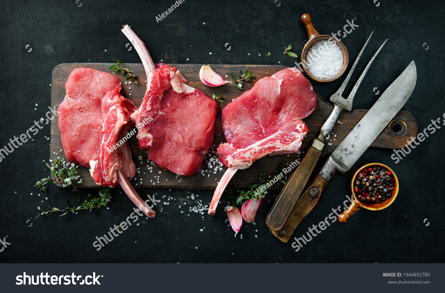 Raw veal meat ribs cutlets with ingredients on rustic dark background, top view. Frenched Racks meat #1944892780