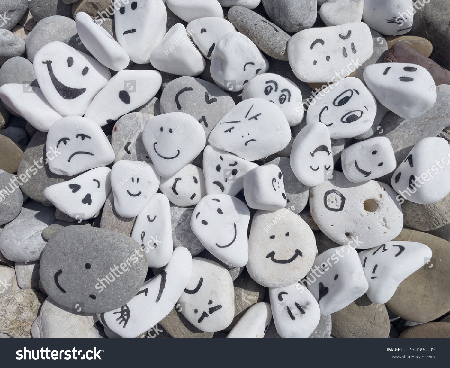 Emotion management concept, stones with painted faces symbolize different emotions. We are all different, but all together, learning to manage emotions. Emotional intelligence, role model. Good mood. #1944994009
