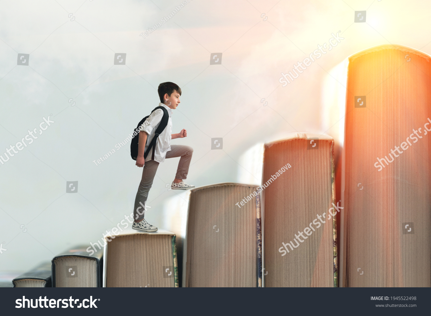 Child climbing stairs made of on sky background. Education or hard study concept. Soft focus #1945522498