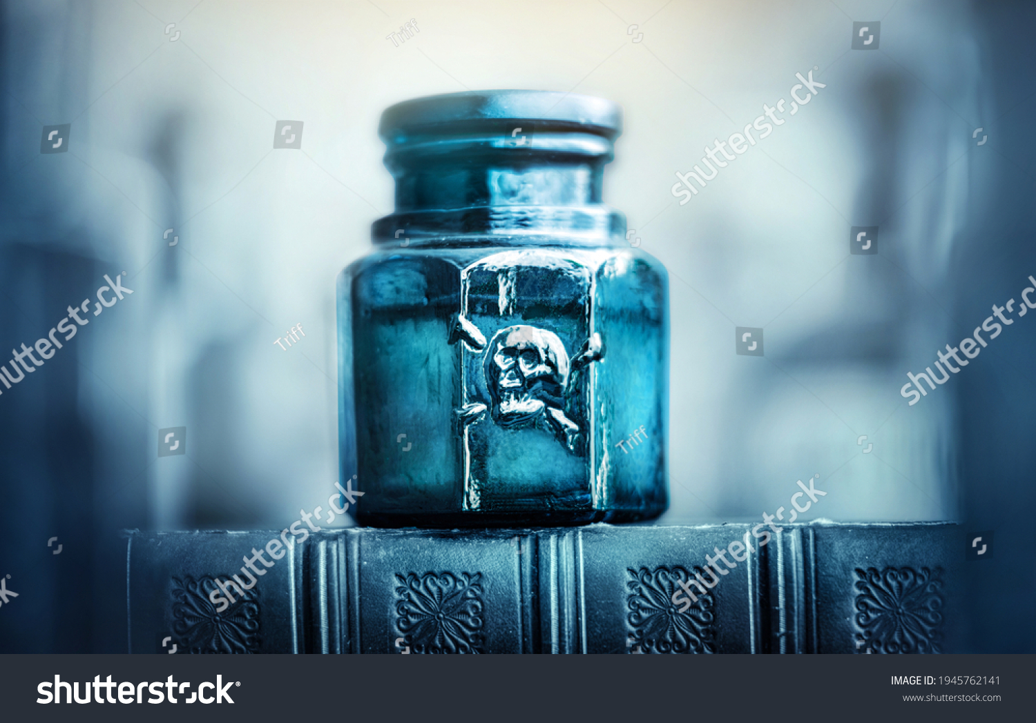 Glass poison bottle with skull and bones. Danger sign, symbol of death. Concept background on poison poisoning, pharmaceutical, chemistry, medical, old science topic. #1945762141