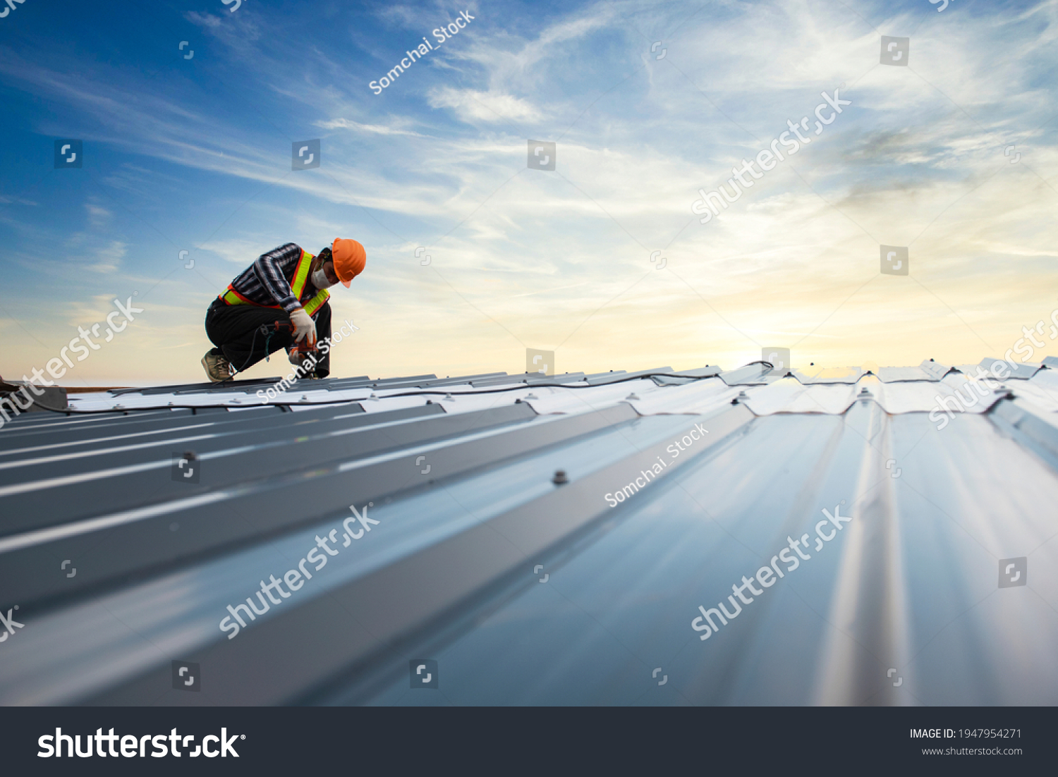 Builders in work clothes install new roofing tools, roofing tools, electric drill and use them on new wooden roofs with metal sheets
 #1947954271