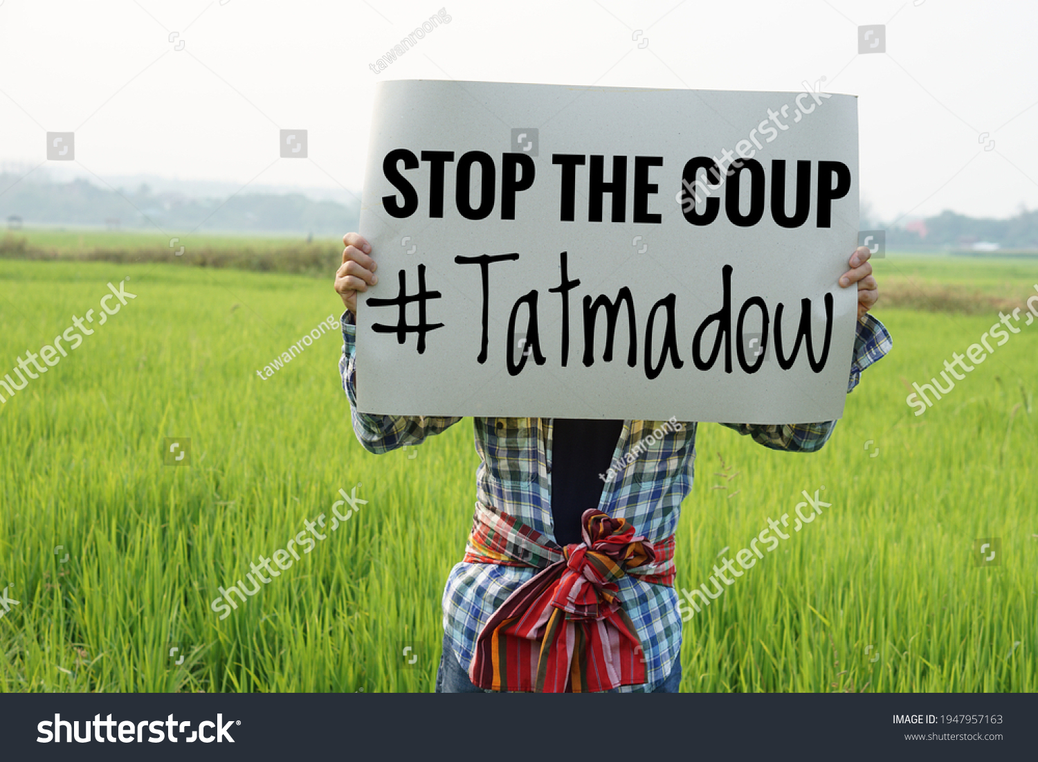 Myanmar man hold paper sign text " Stop the coup #Tatmadow". Concept protest the violence from the coup  in Myanmar. #1947957163