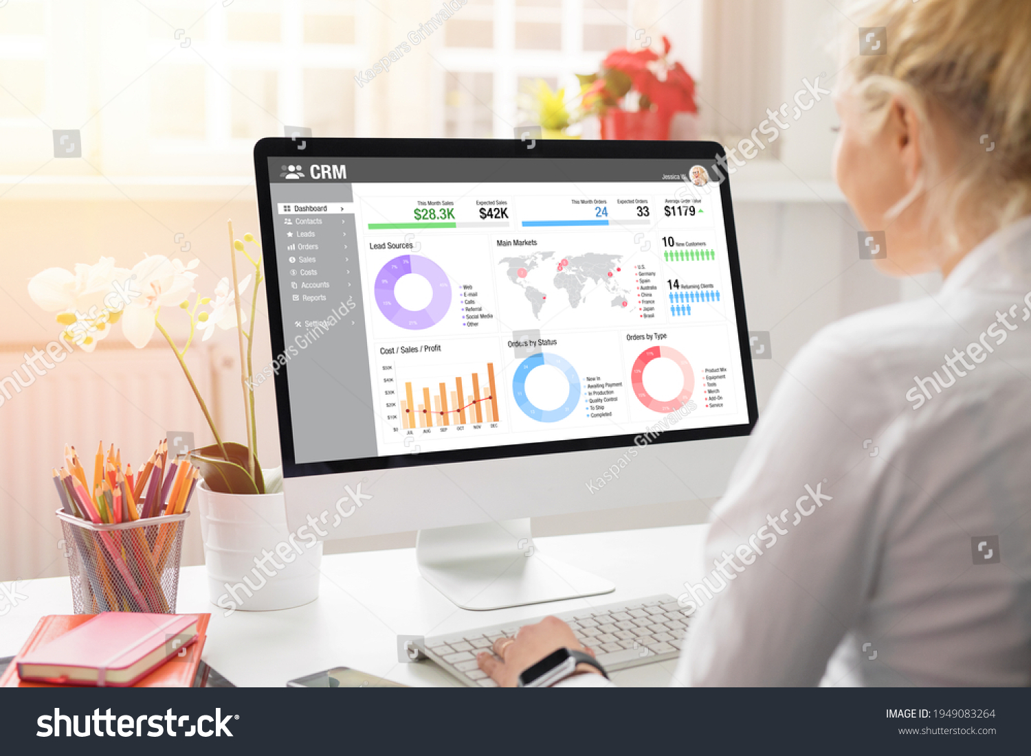 Girl working with desktop computer in office. Viewing different charts, graphs and infographics of CRM on the computer screen. #1949083264