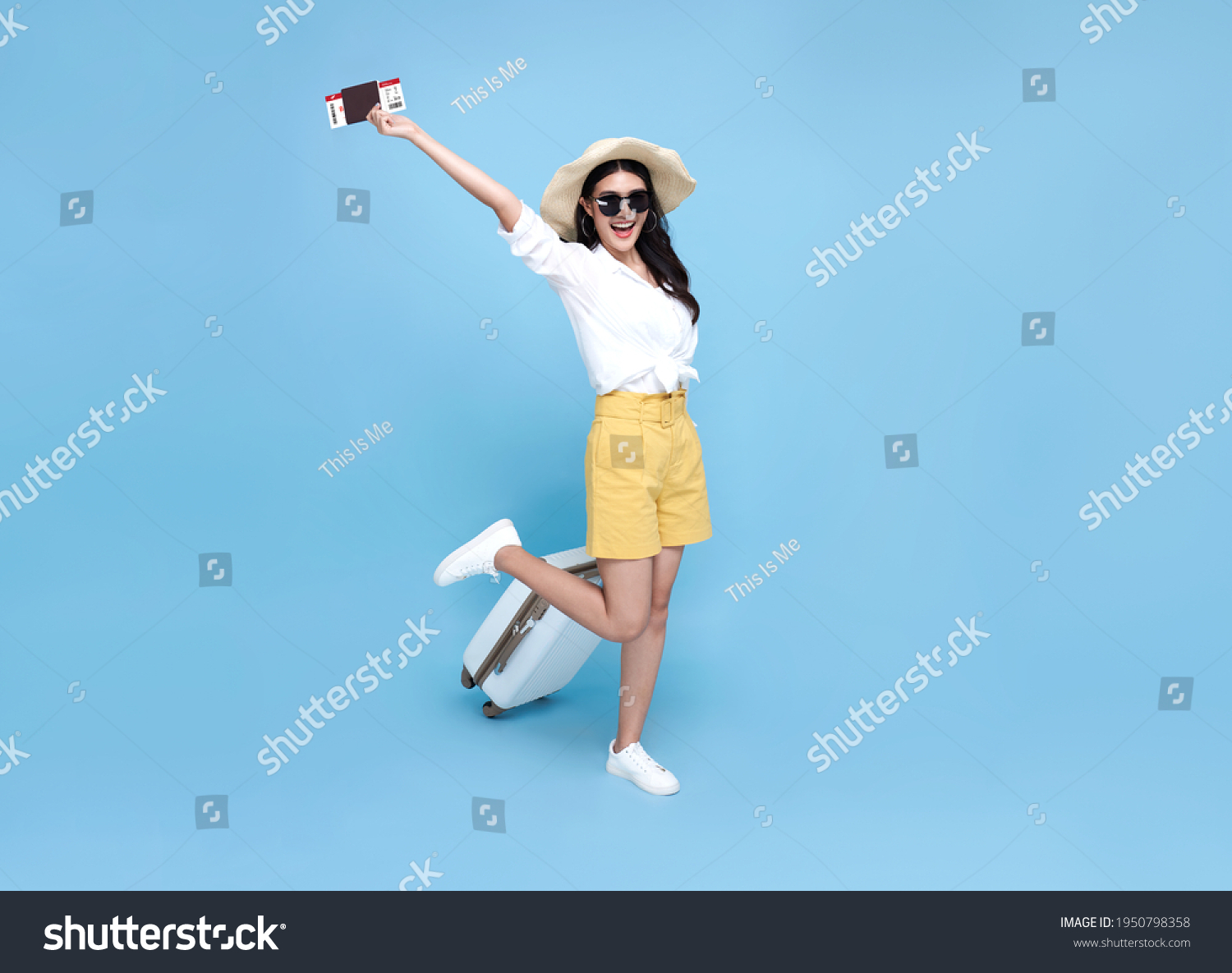 Happy smiling Asian woman dressed in summer clothes with passport and luggage enjoying their summer vacation getaway in blue background. #1950798358
